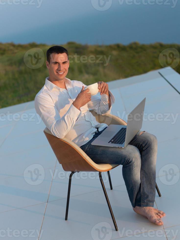 relaxed young man at home on balcony photo