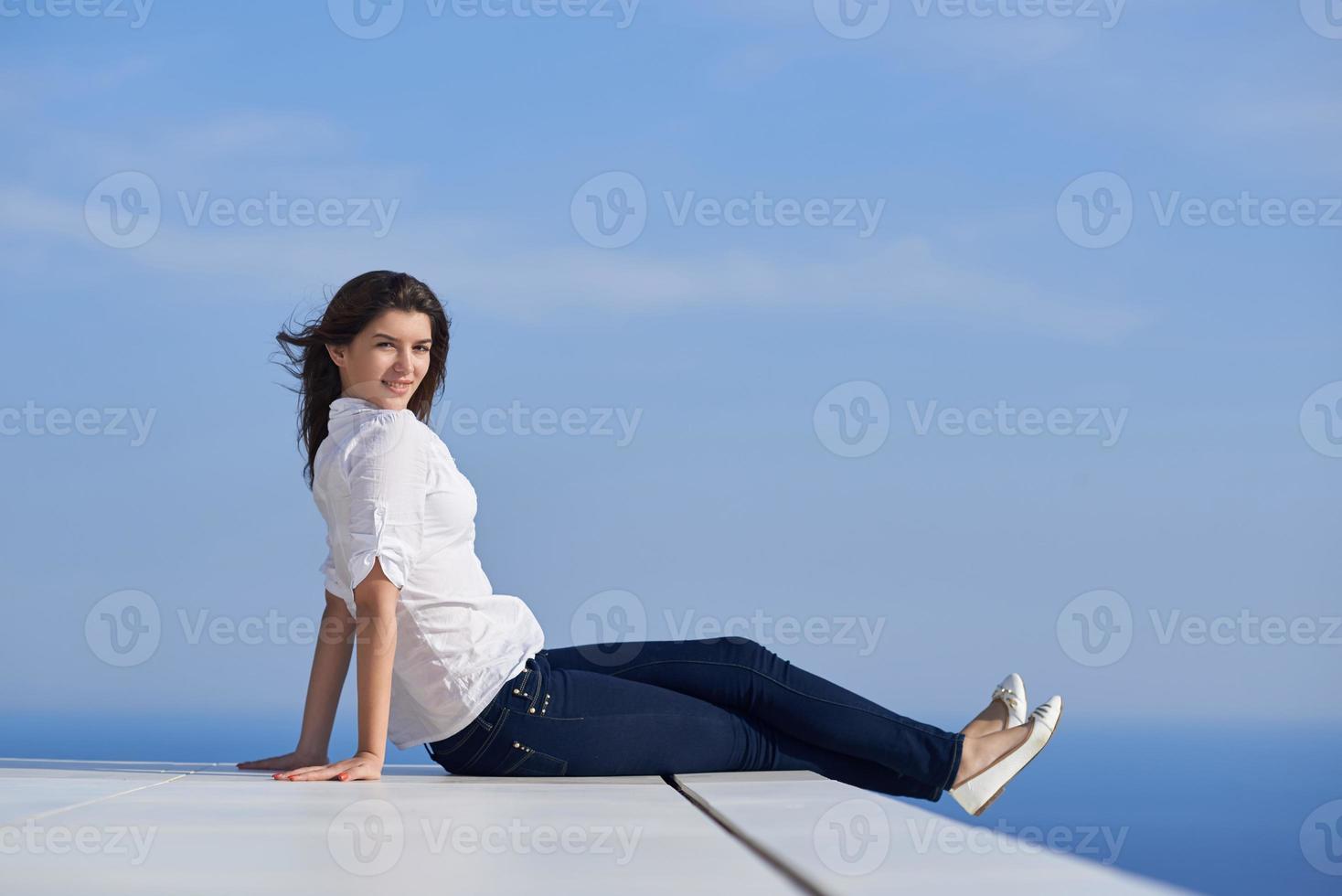 relaxed woman in front of luxury modern home photo