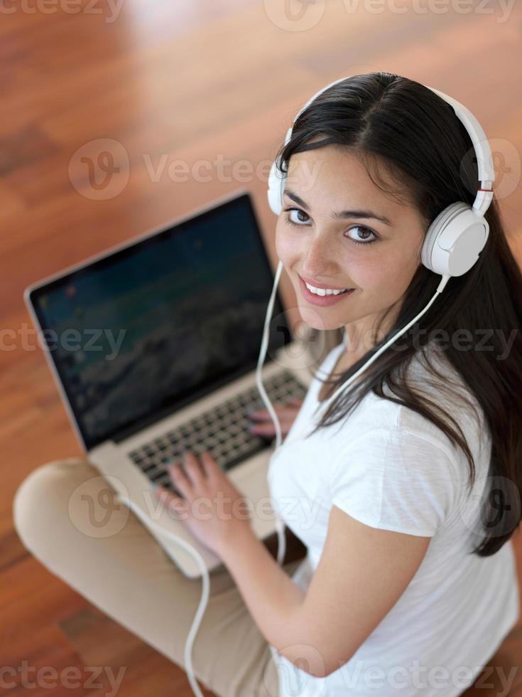 relaxed young woman at home working on laptop computer photo