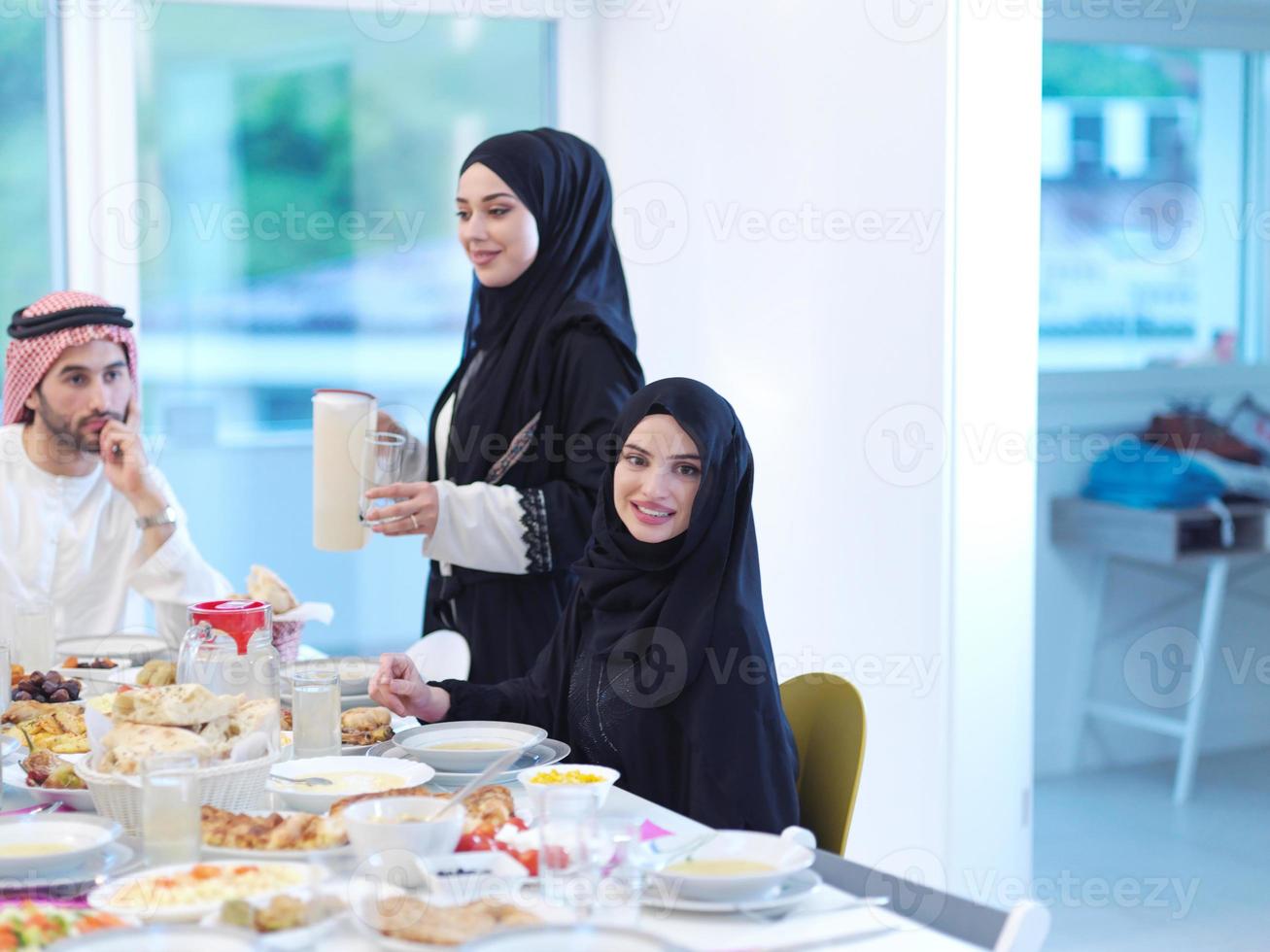 Muslim family having Iftar dinner drinking water to break feast photo