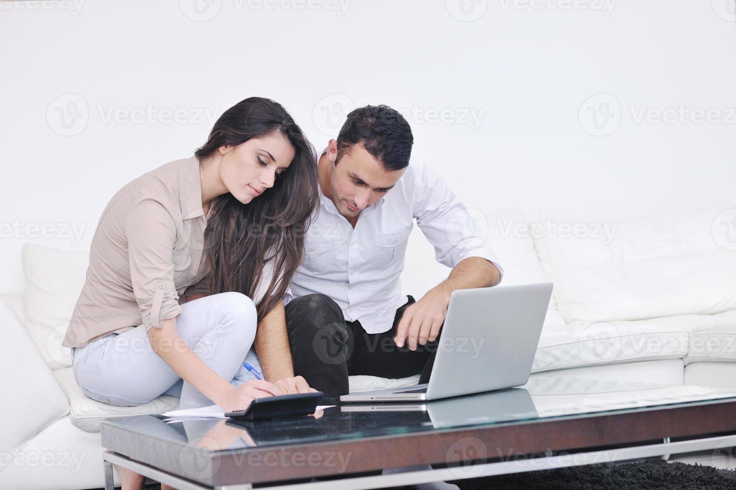 joyful couple relax and work on laptop computer at modern home photo