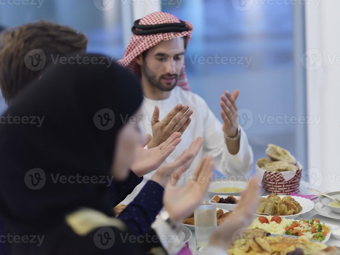 Muslim family making iftar dua to break fasting during Ramadan photo