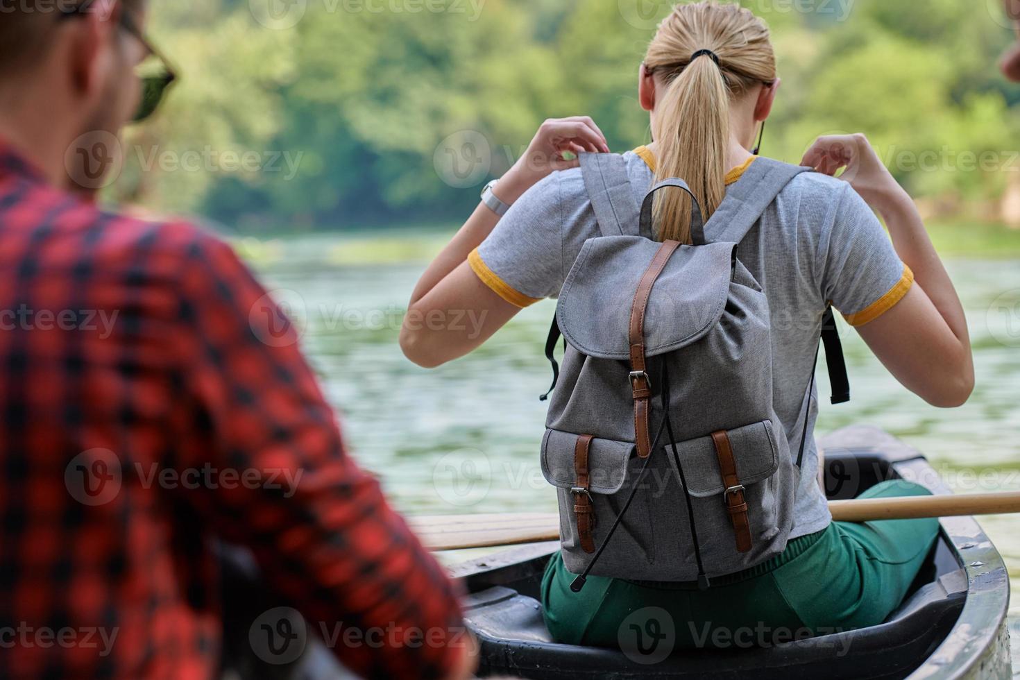 friends are canoeing in a wild river photo