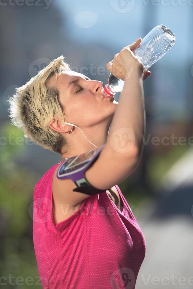 woman drinking  water after  jogging photo