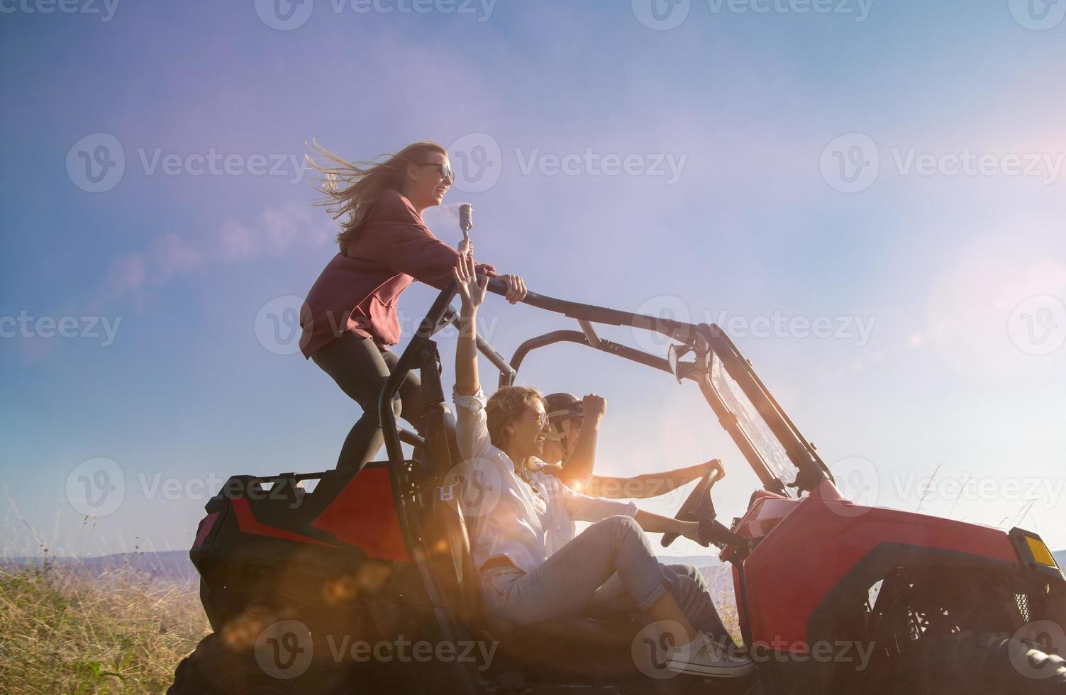 grupo de jóvenes divirtiéndose mientras conducen un camión todoterreno foto