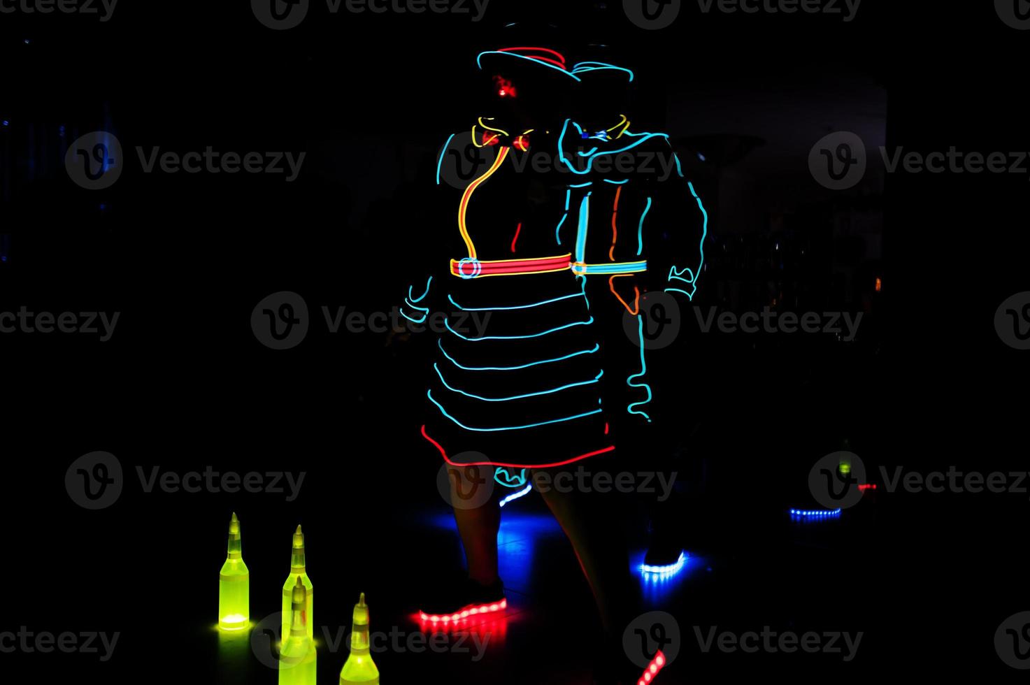 Professional barman and led light show. Silhouette of modern bartender shaking drink at night cocktail bar. photo