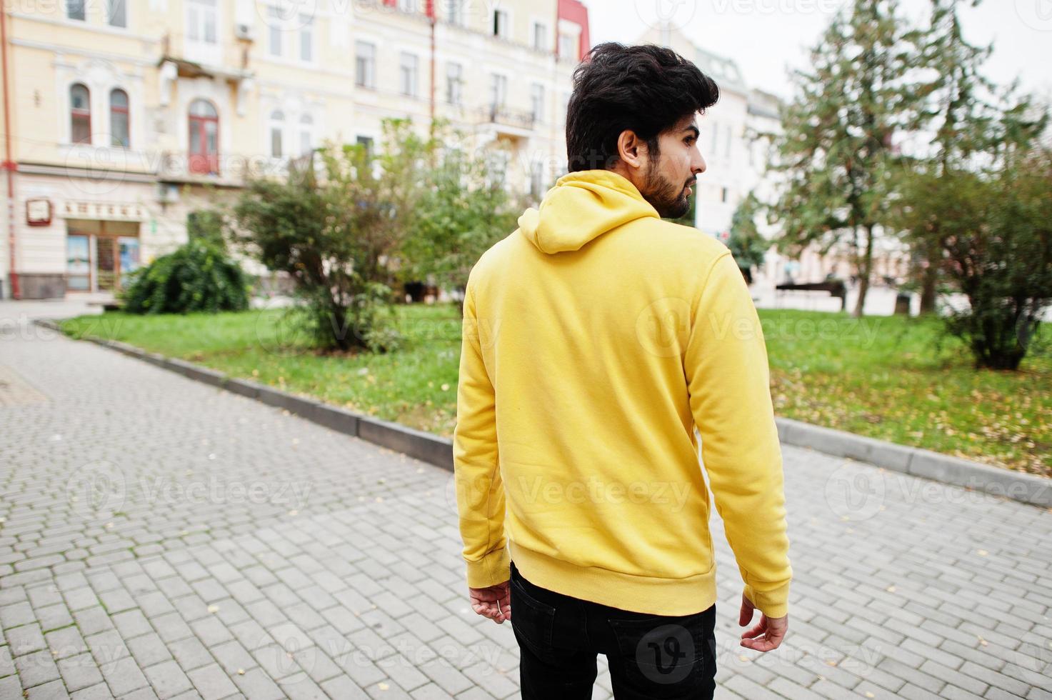 hombre indio joven hipster urbano en una sudadera amarilla de moda