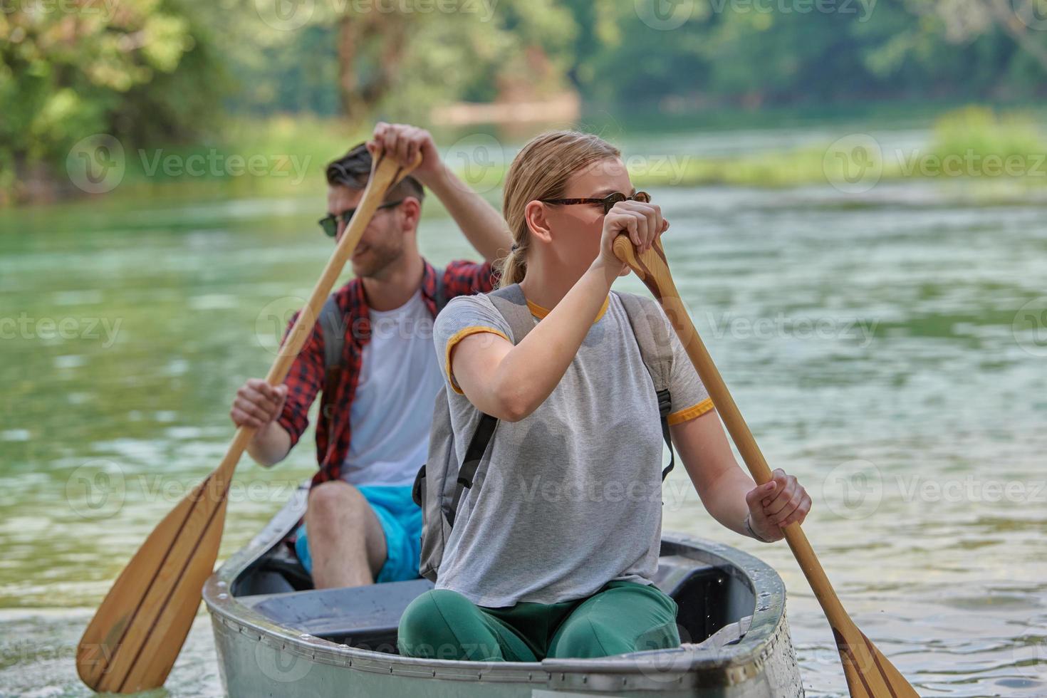 friends are canoeing in a wild river photo