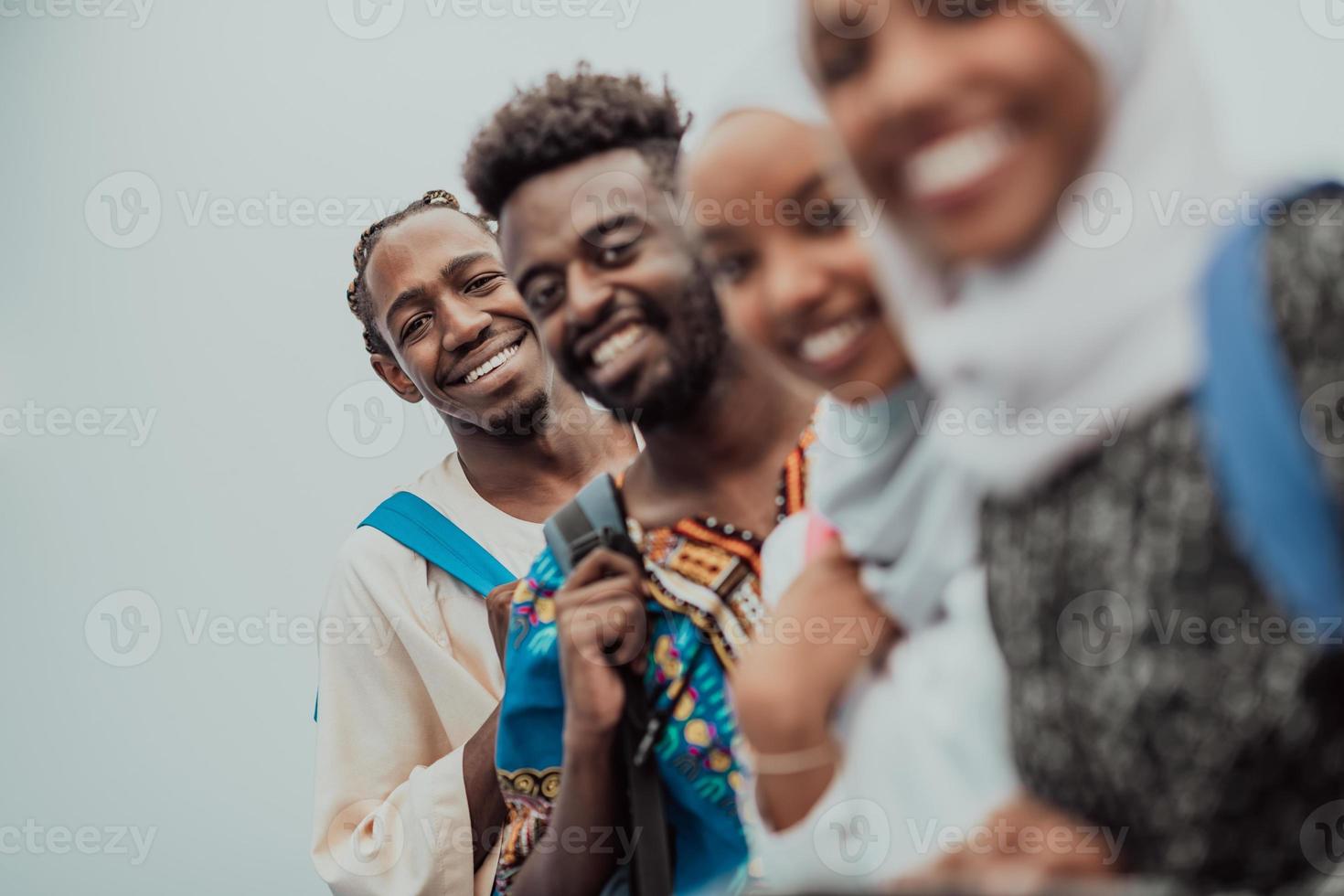 Photo of a group of happy african students talking and meeting together working on homework girls wearing traditional Sudanese Muslim hijab