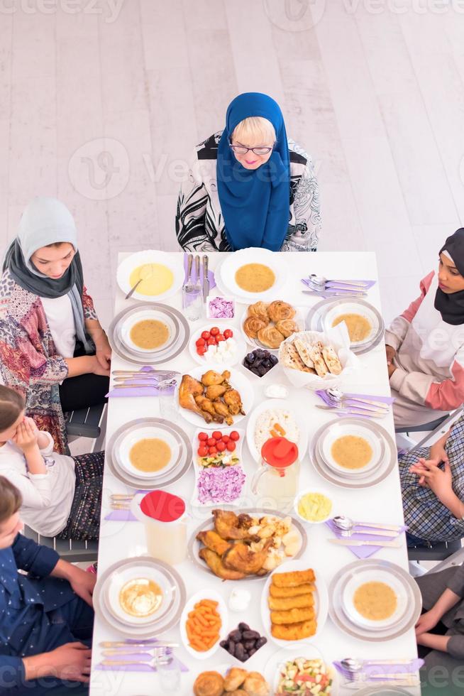 vista superior de la familia musulmana multiétnica moderna esperando el comienzo de la cena iftar foto