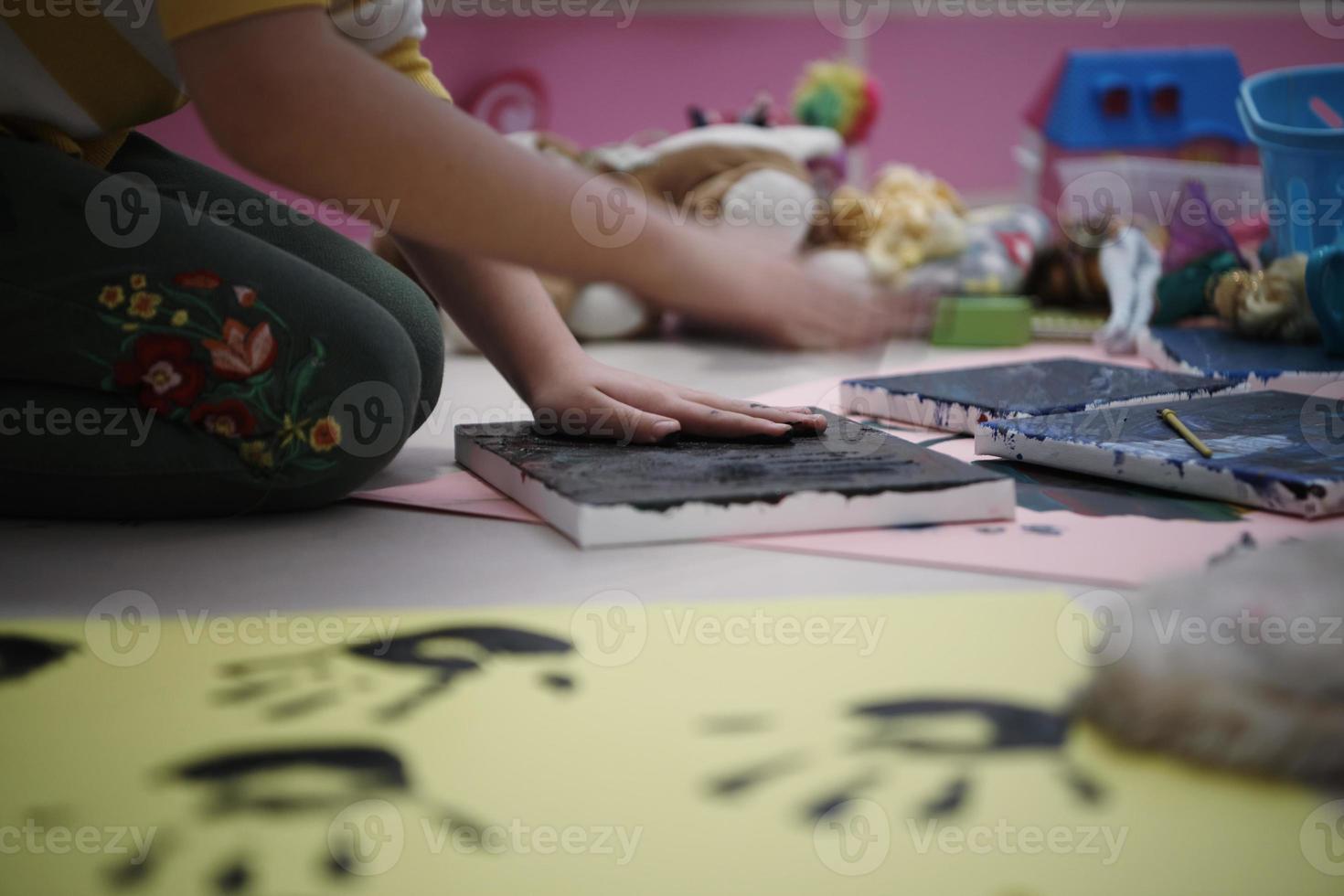 cute little girl at home painting with hands photo