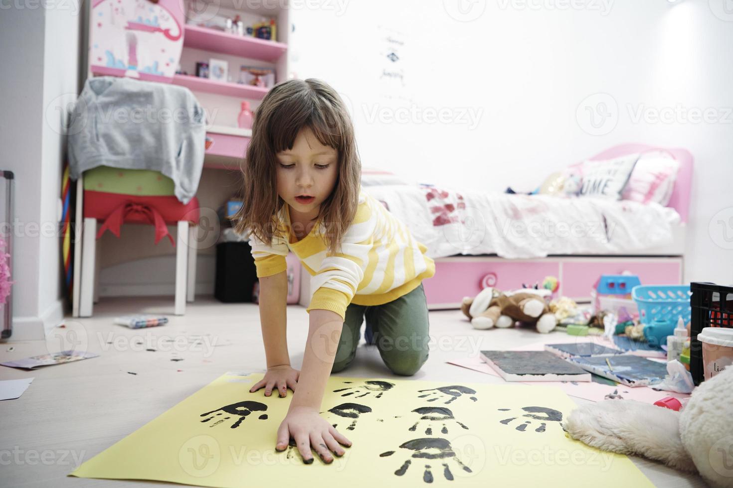 cute little girl at home painting with hands photo