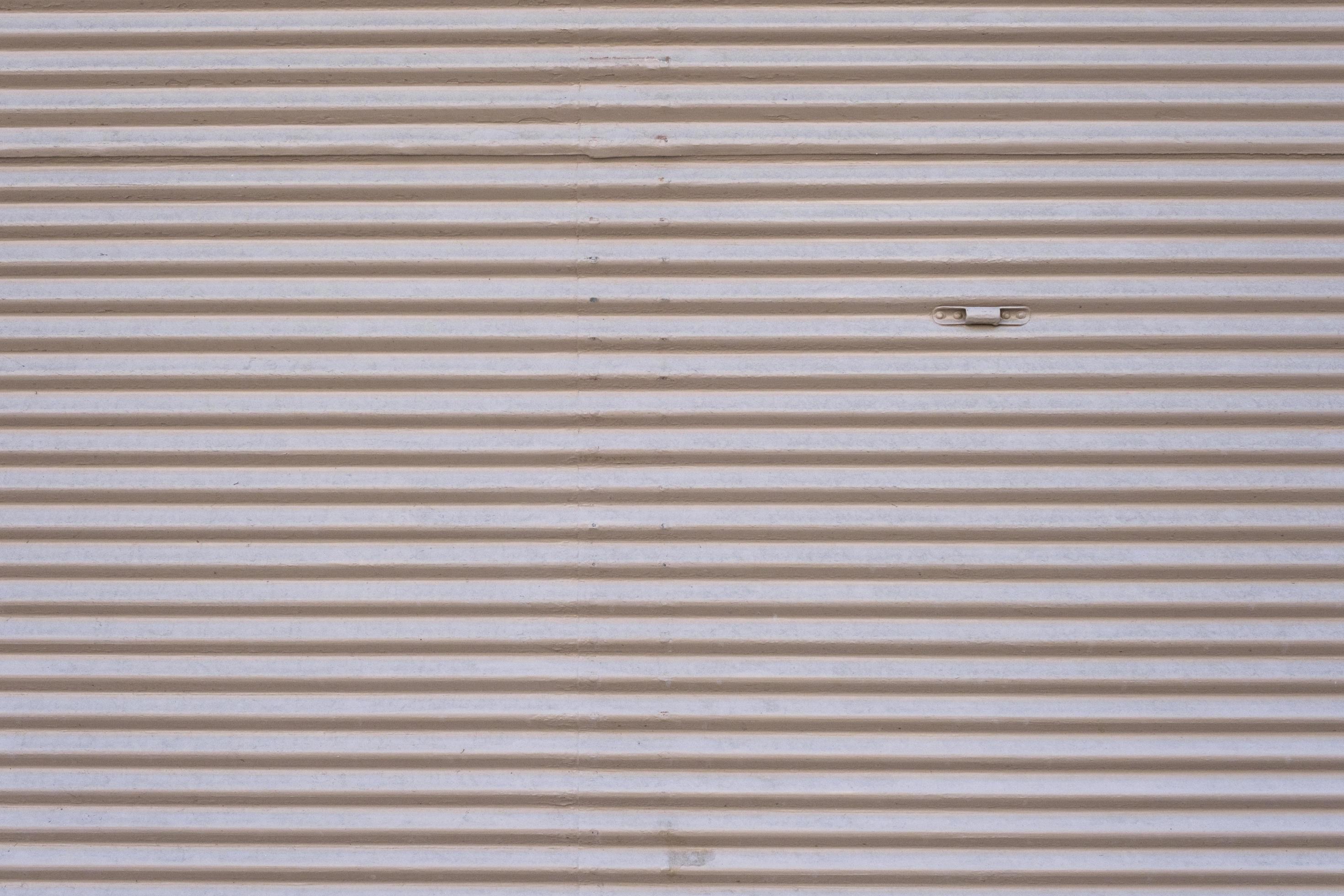 Grey vintage striped door, closeup of garage steel wall texture