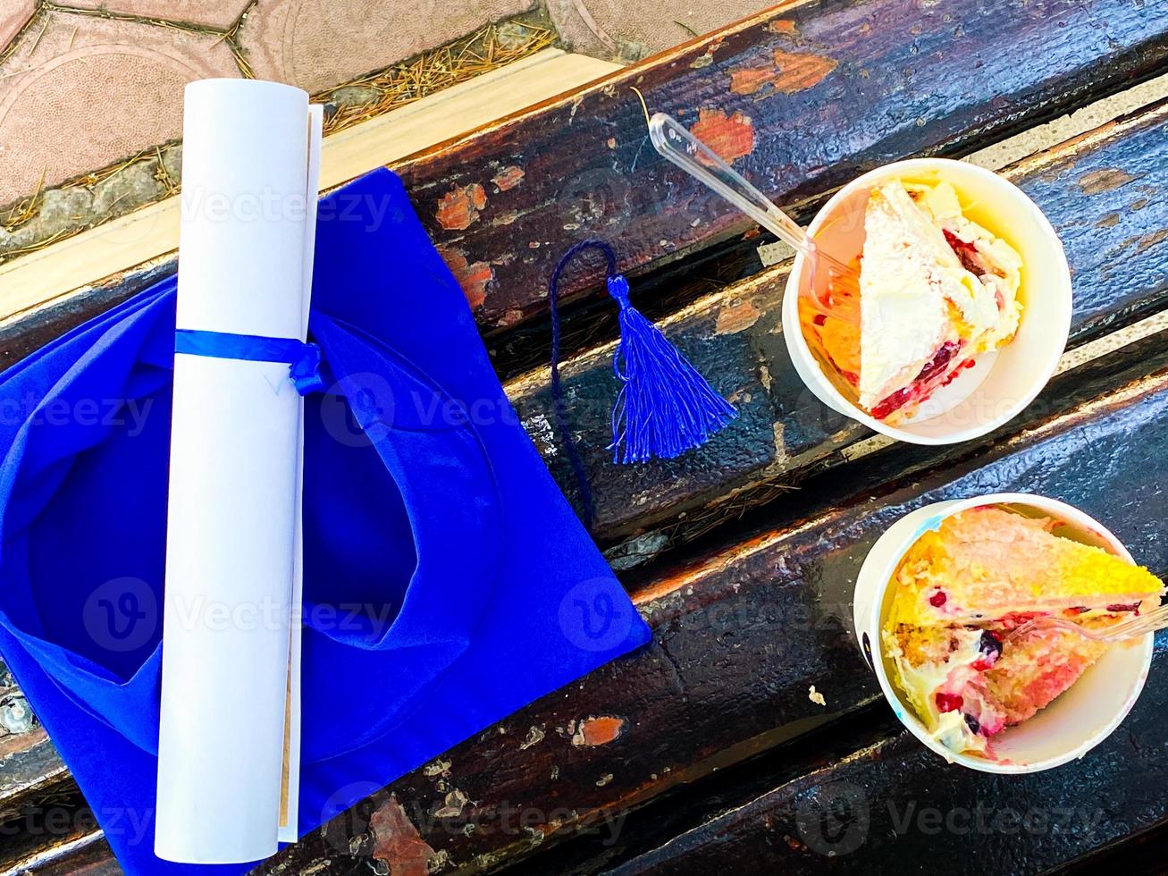 Graduation oath paper with tassel and two party cakes in paper cups on graduation day event in Tbilisi, Georgia photo