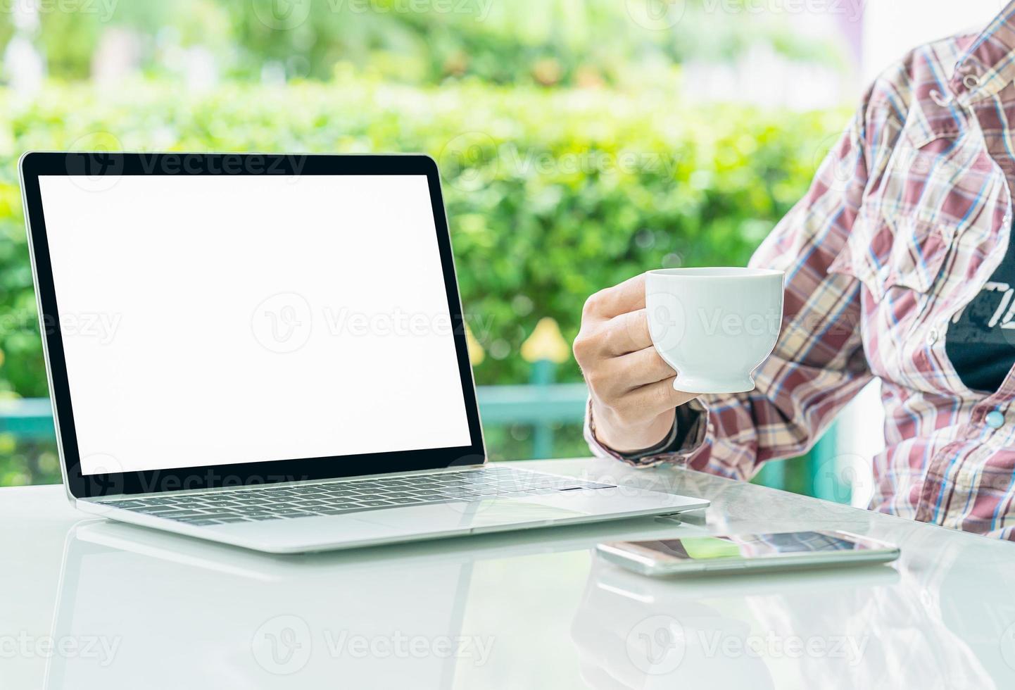 computadora portátil y taza de café en la mesa foto
