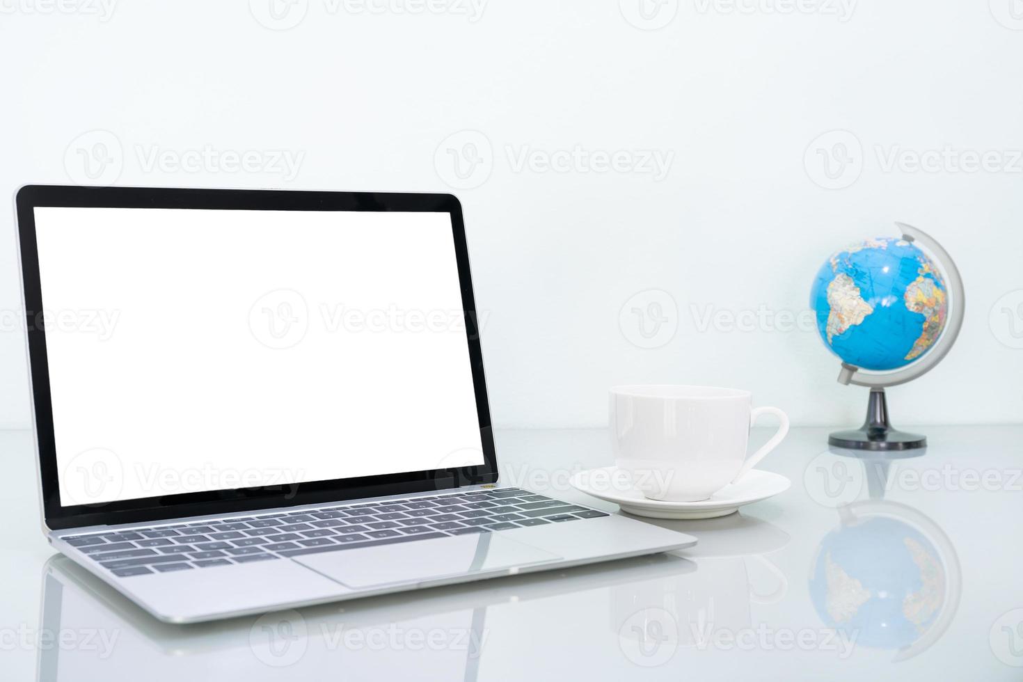 maqueta de computadora portátil y taza de café en la mesa foto