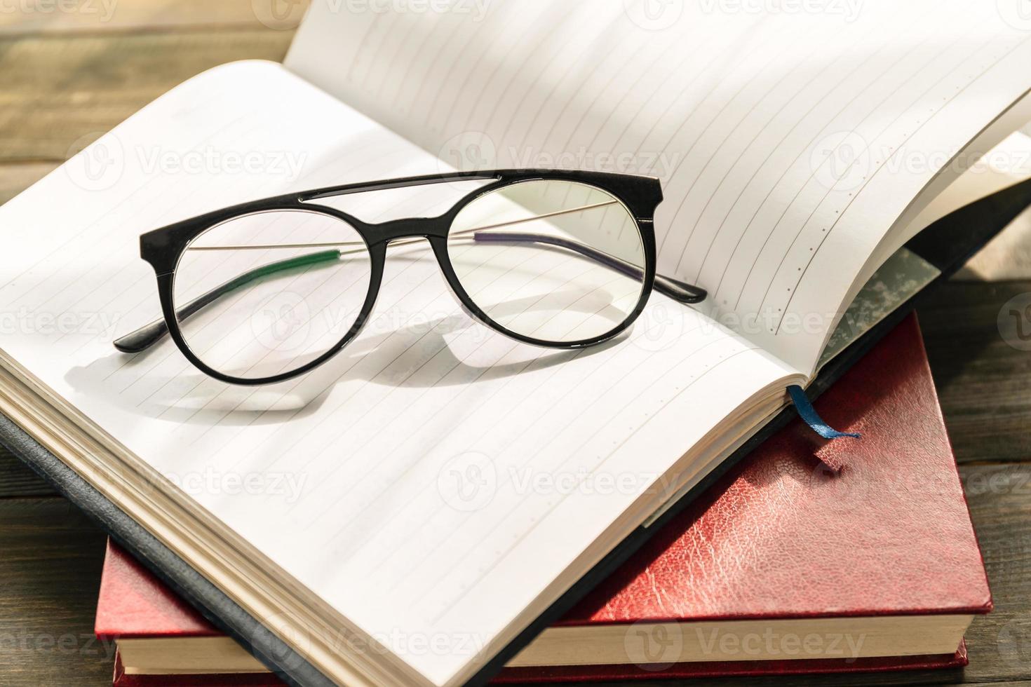 Reading glasses put on open book photo