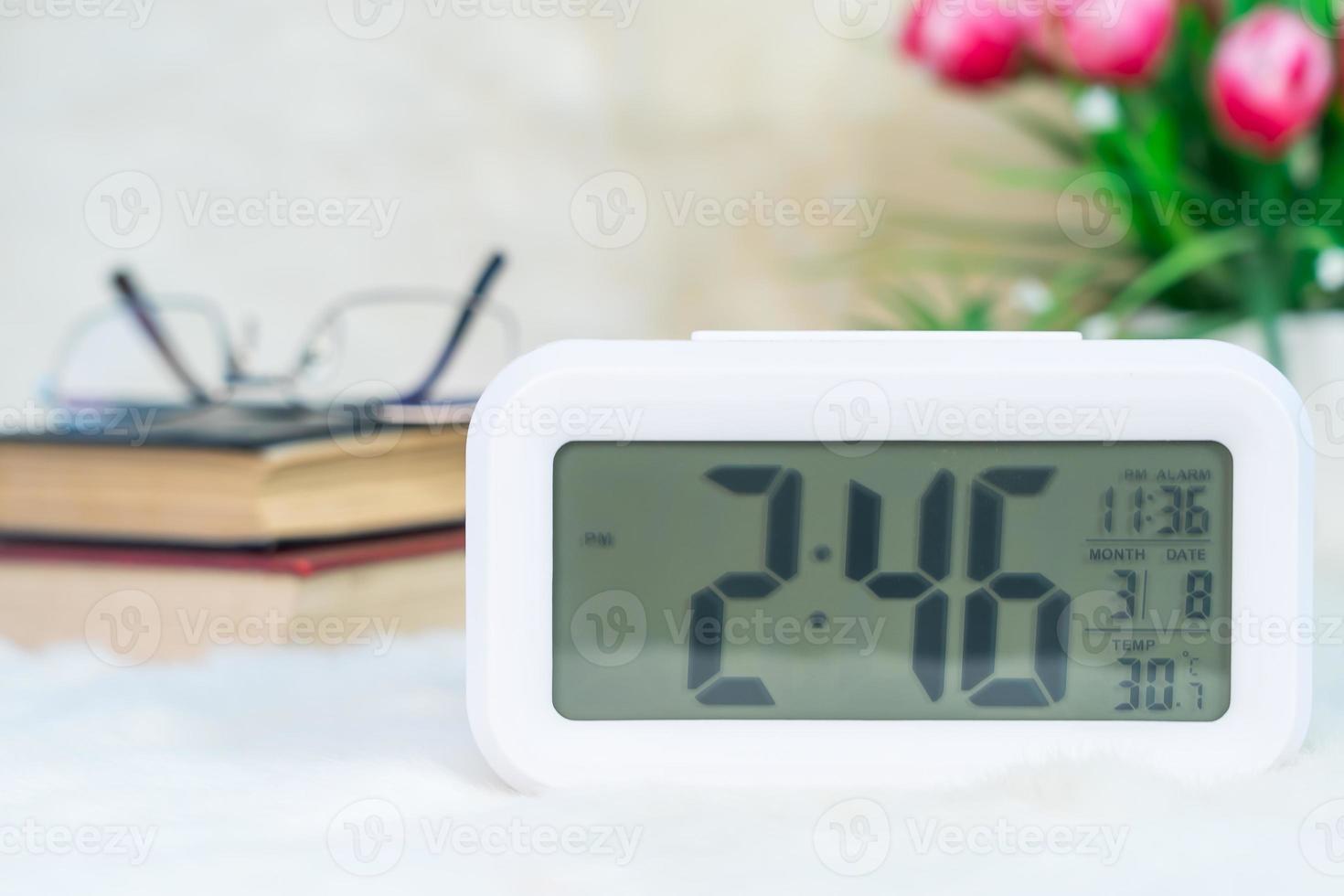 Digital clock with book decorated on table photo