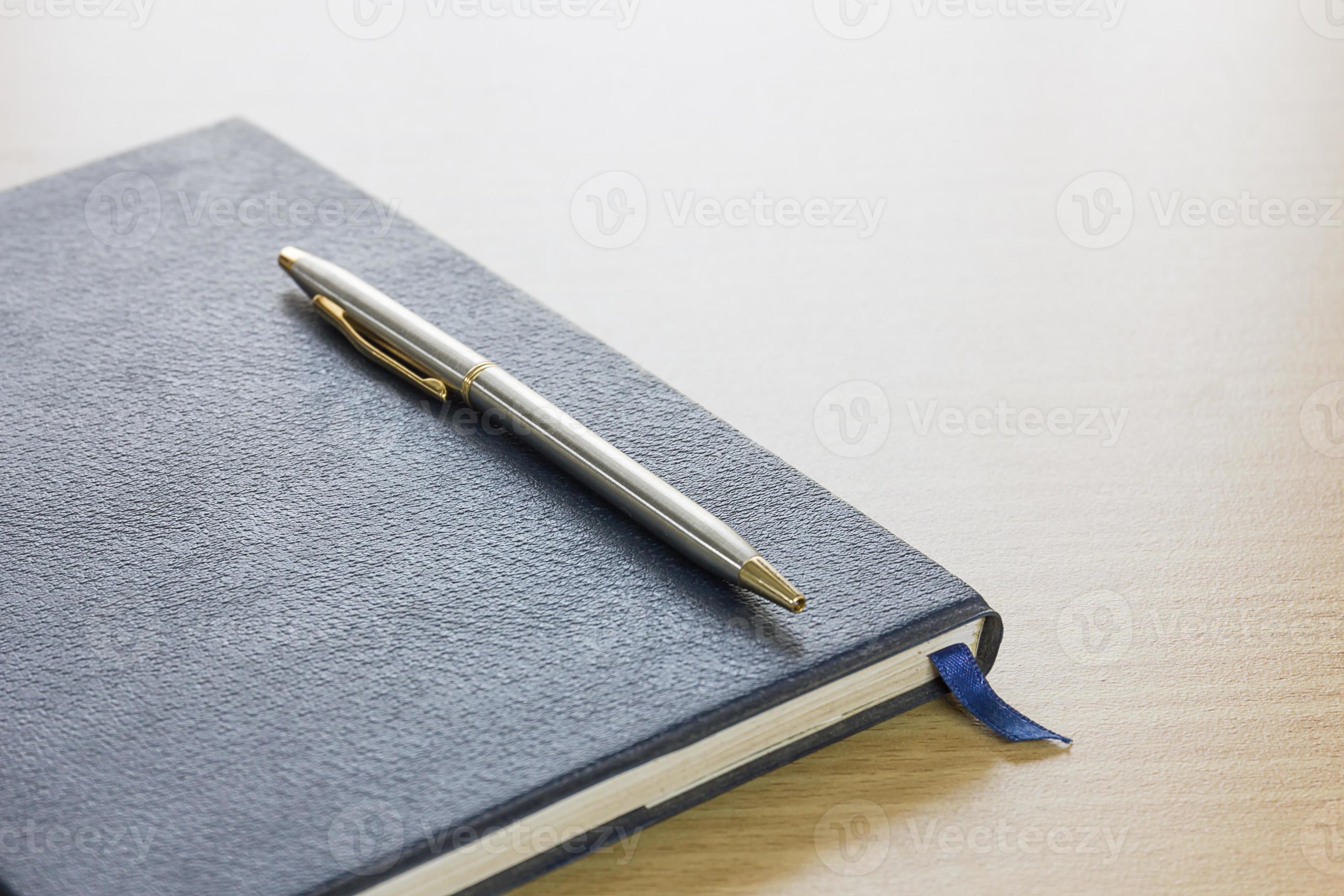 pen-on-a-book-10968928-stock-photo-at-vecteezy