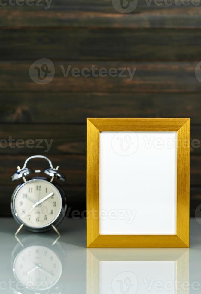 Mockup with golden frame and alarm clock photo