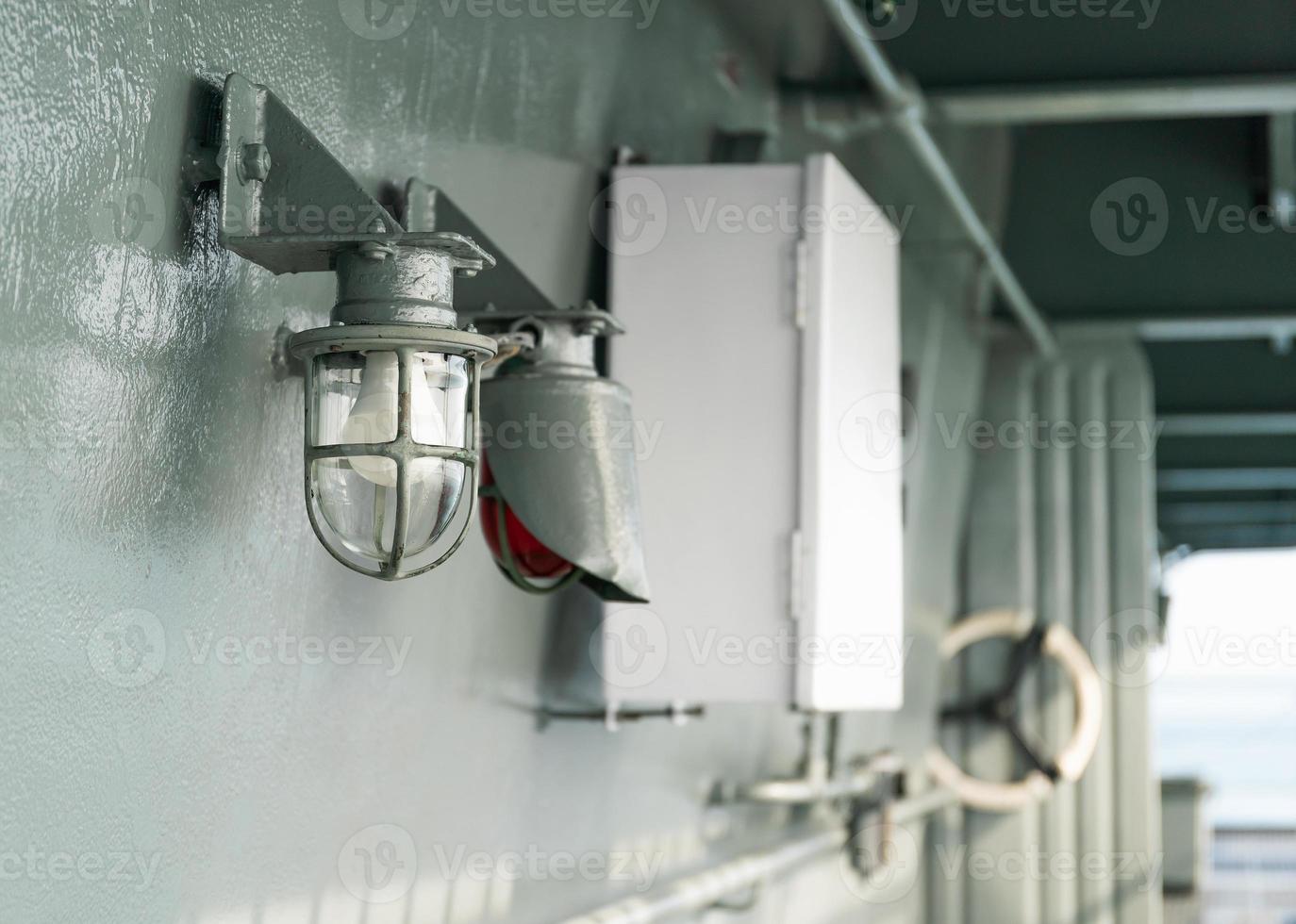 Deck lamp on ship in protective cage photo