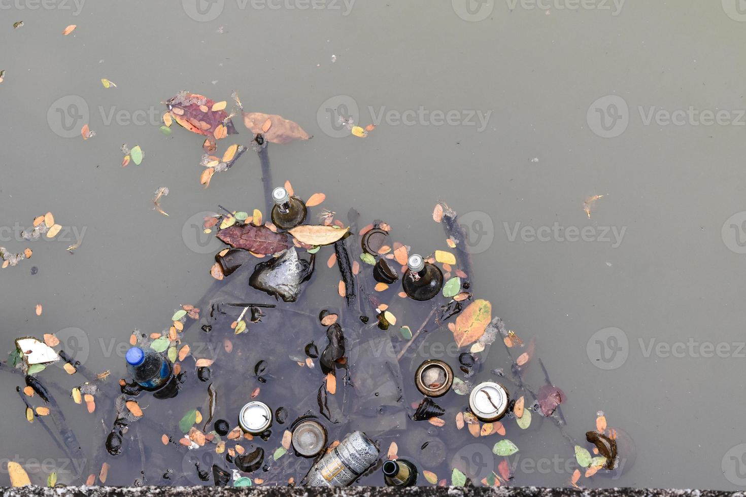 Garbage and bottle in the canal water. top view photo