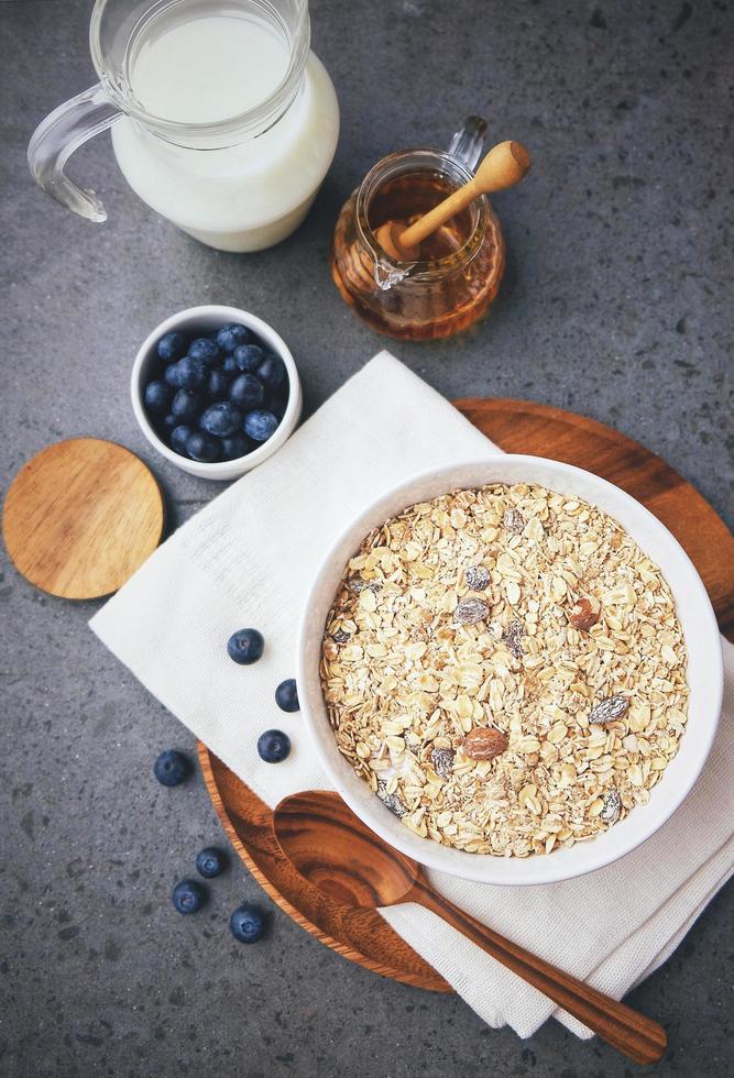 vista superior de cereales orgánicos y arándanos frescos con leche para un desayuno saludable, concepto listo para comer foto