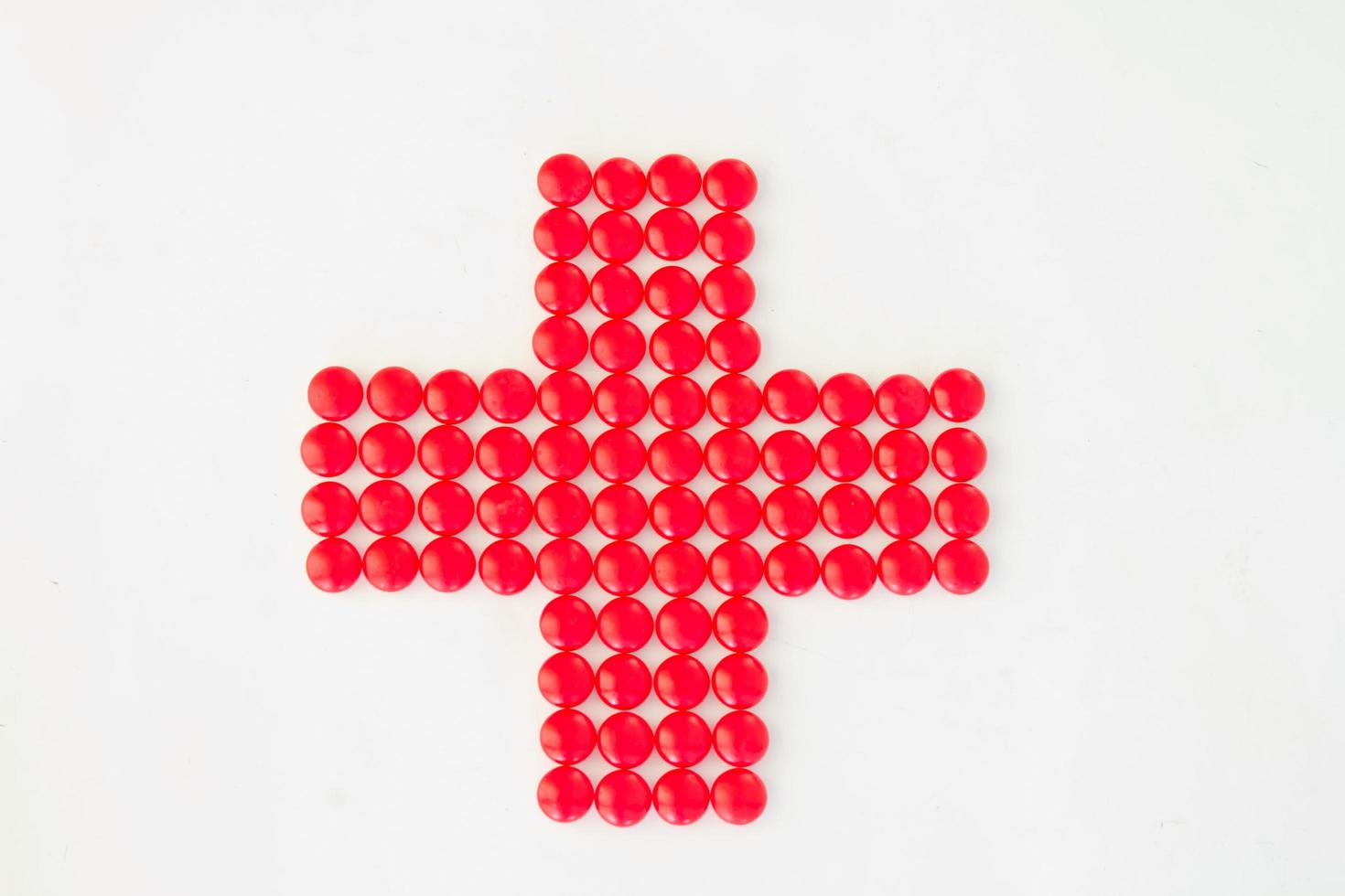 cruz roja hecha con pastillas rojas foto