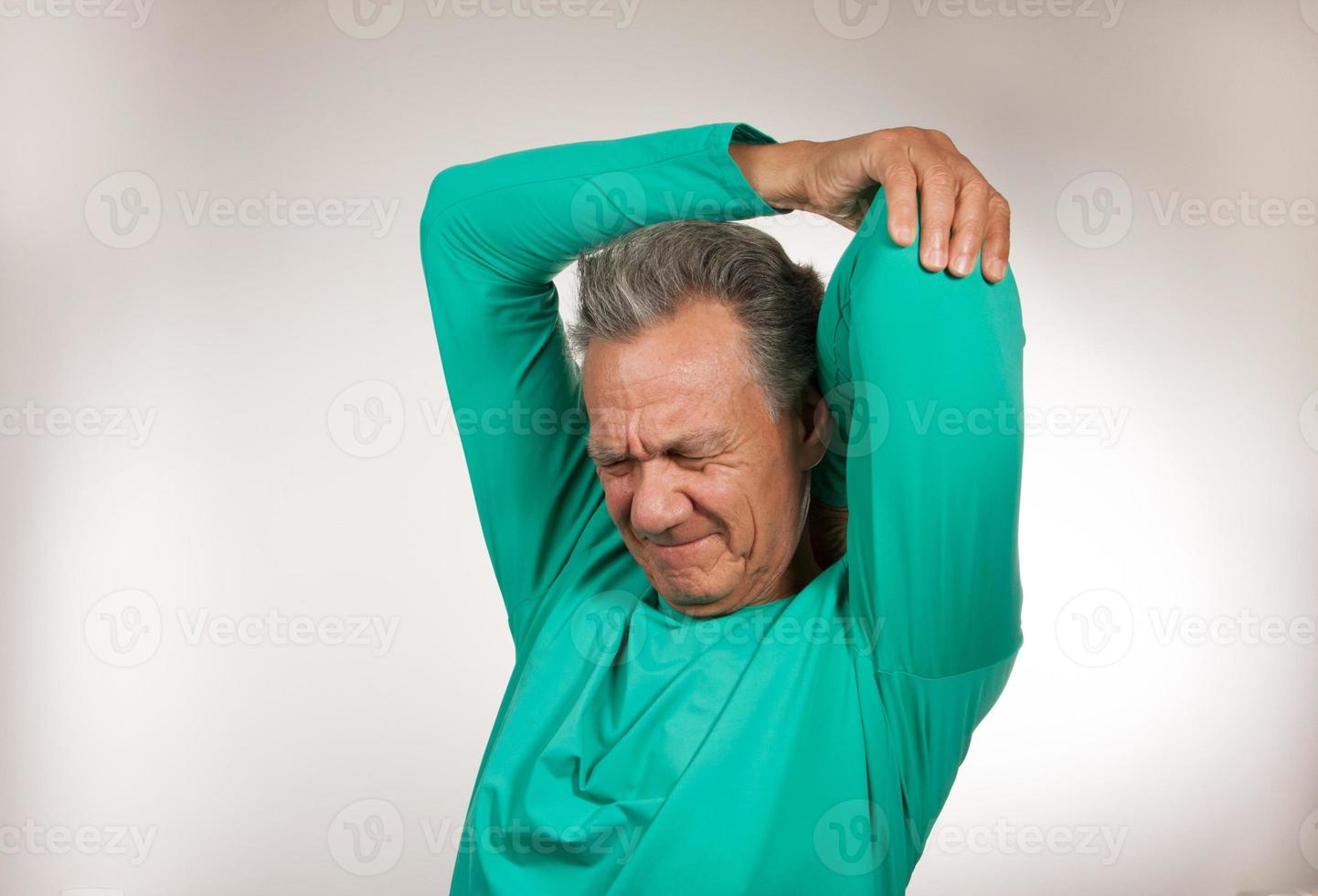 Mature Man 60plus doing back of the neck stretches for back and neck pain photo