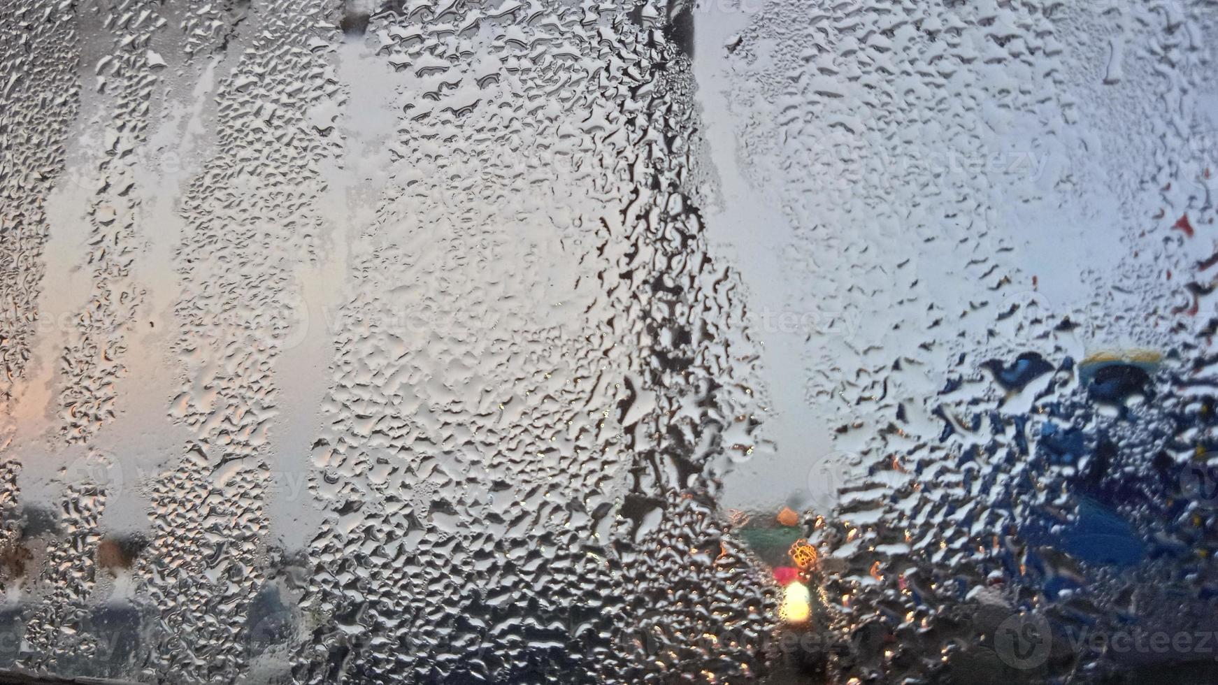 vista desde la ventana en la mañana fría con gotas de lluvia de agua sobre el vidrio foto