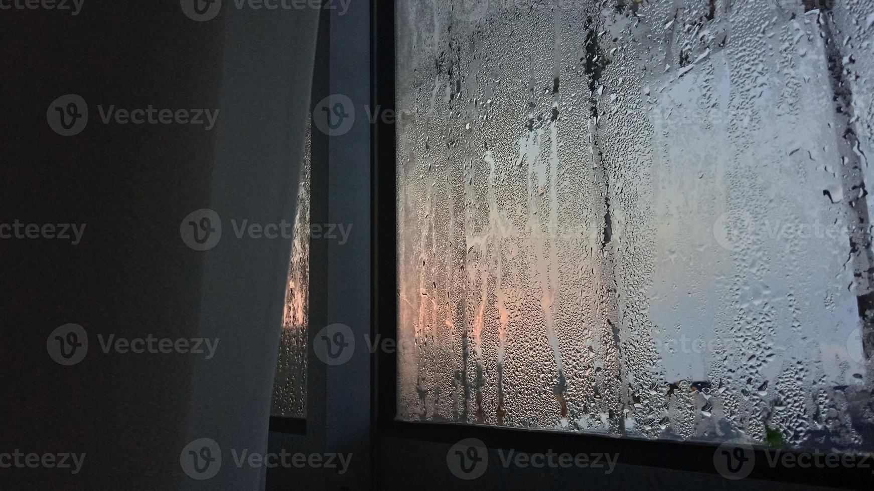 view from the window in the cold morning with water rain drops on glass photo