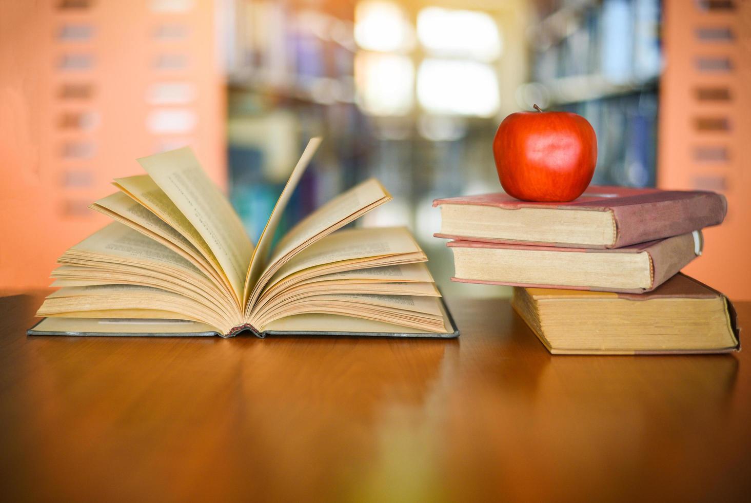 libros sobre la mesa con estantería en el fondo de las estanterías de la biblioteca - concepto de aprendizaje educativo pila de libros abiertos foto