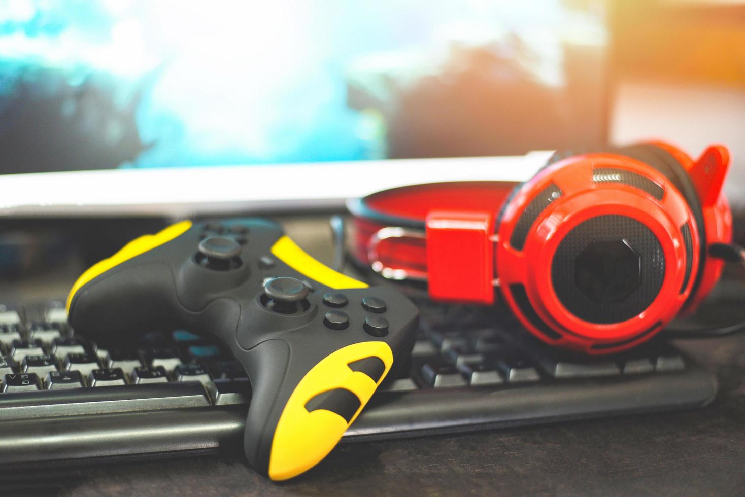 joystick de game pad y auriculares en el teclado jugando juegos y viendo videos en la televisión o en la consola de juegos de computadora foto