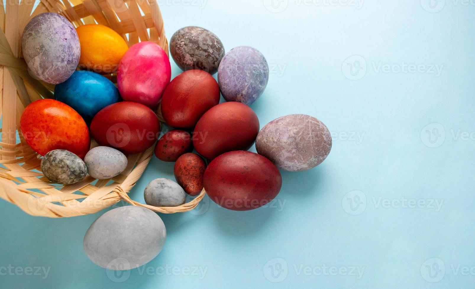 huevos coloridos derramados fuera de la canasta. el concepto de pascua foto