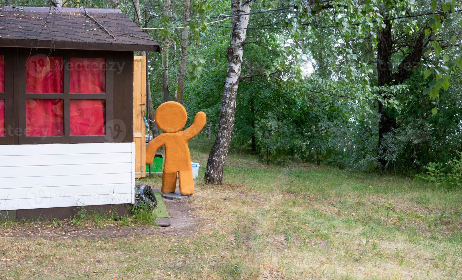 Christmas gingerbread comes into the house in the park in the summer photo