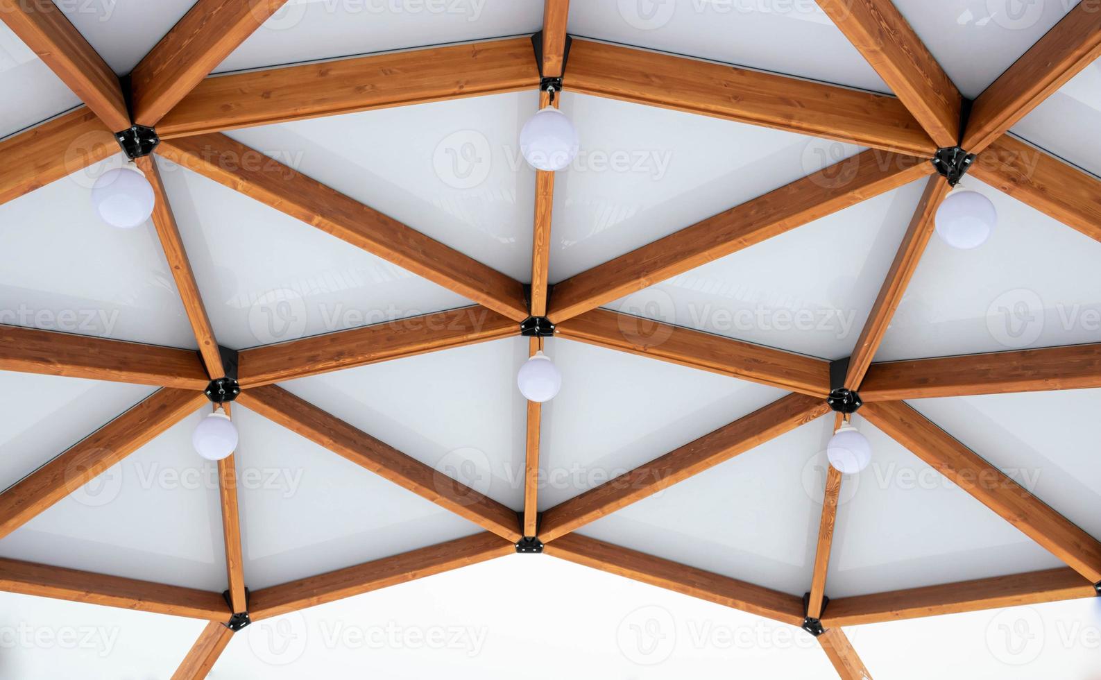 Glass ceiling with lanterns in a brown wooden gazebo outdoors in winter photo