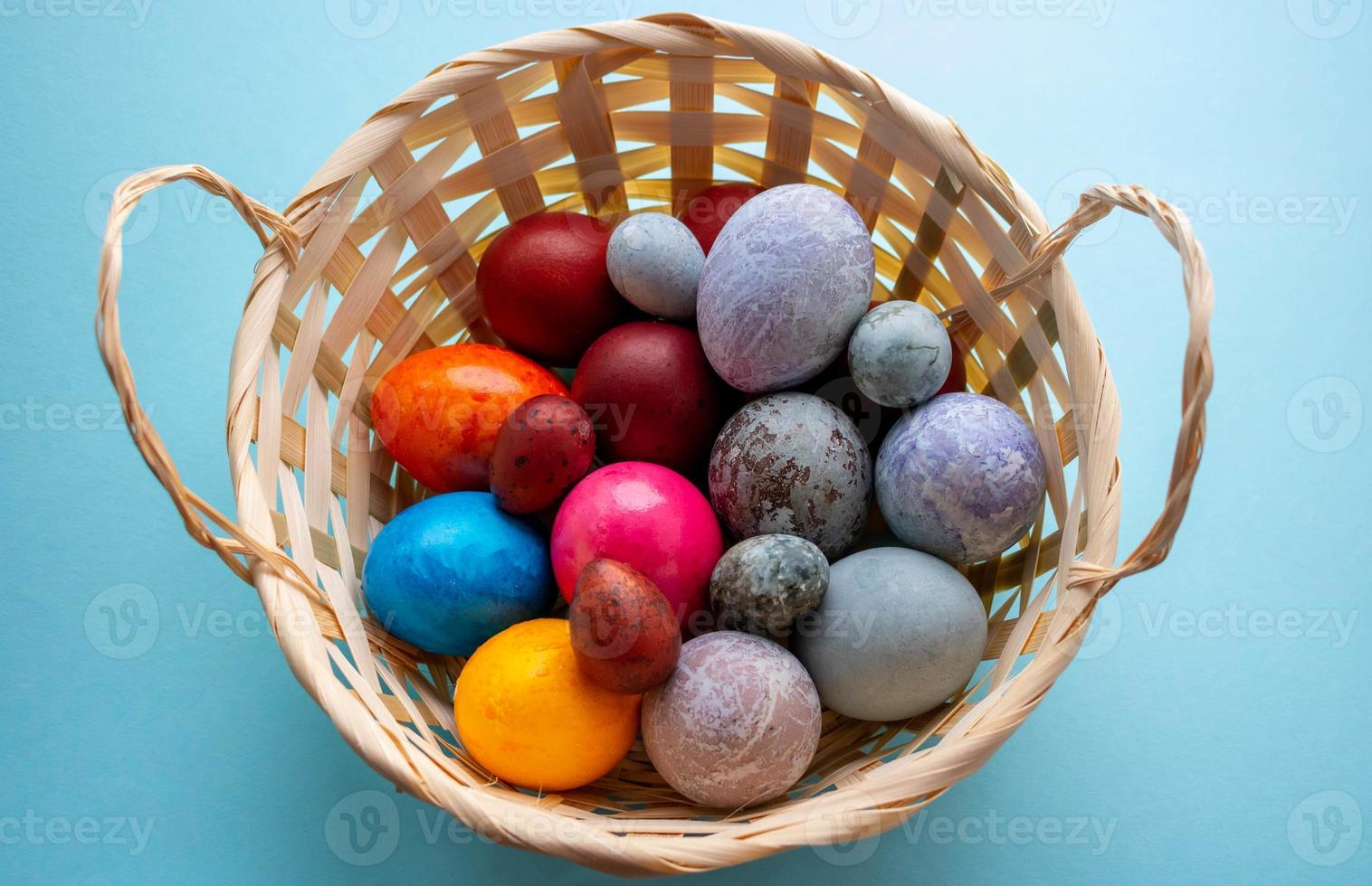 On a blue background, a basket with colorful Easter eggs.The Concept Of Easter photo