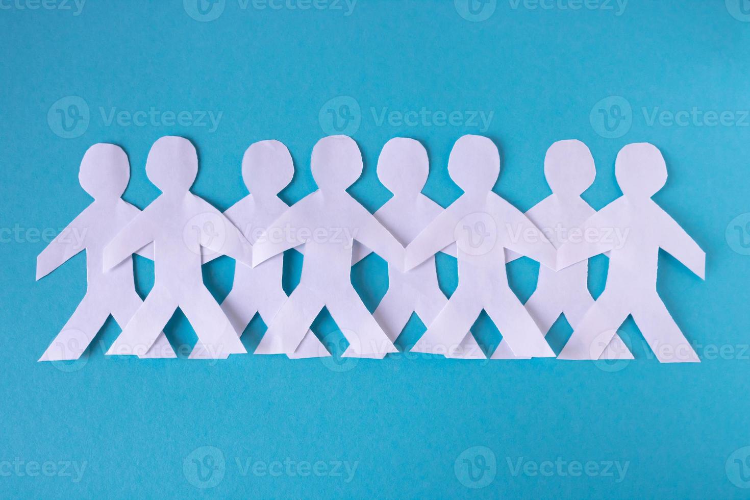 People cut out of paper on a blue background. The concept of the World Peace Day. photo