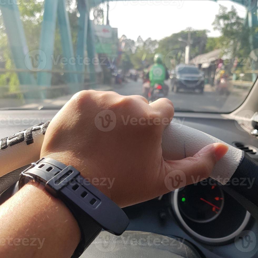 A hand is holding the steering wheel. photo