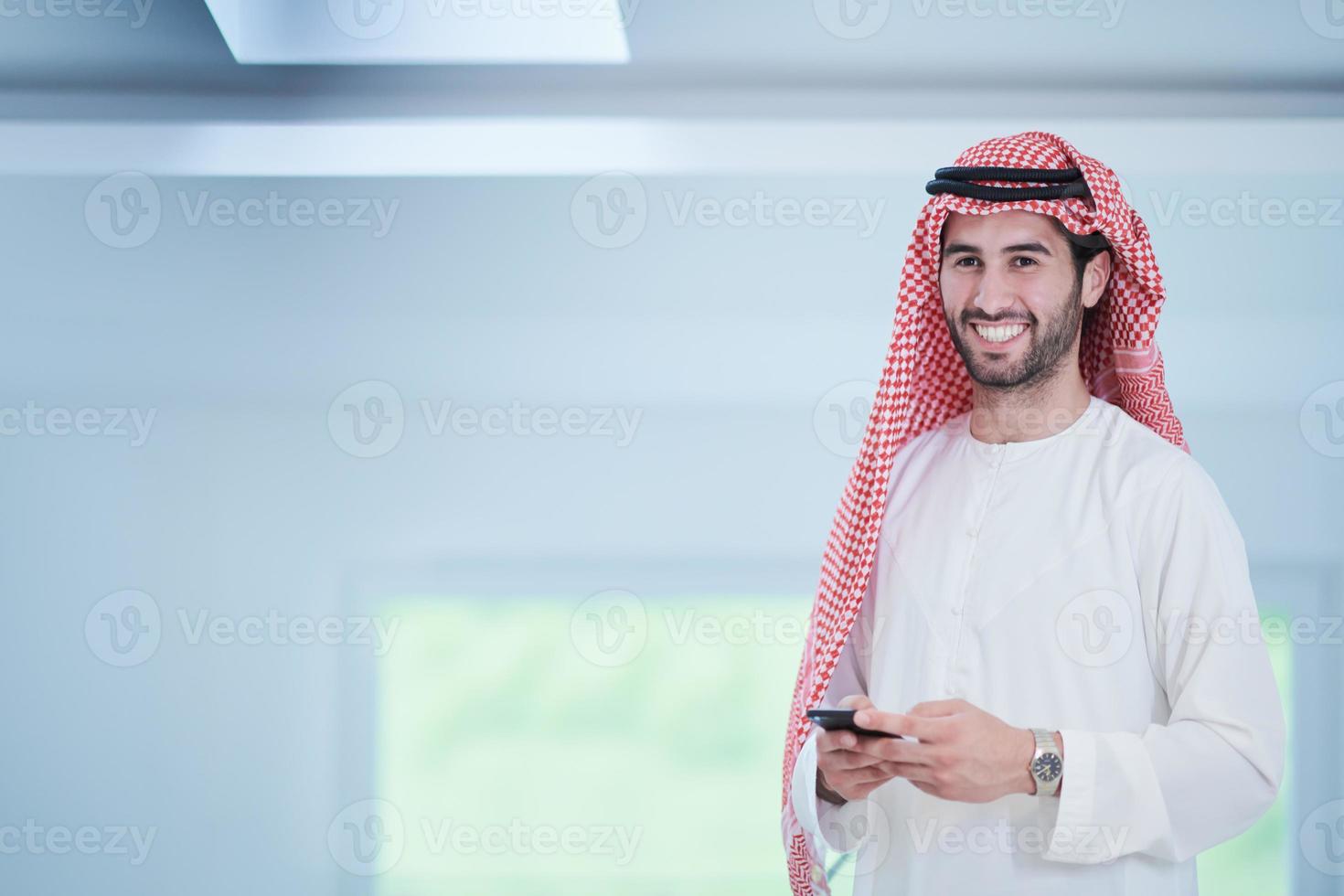 young arabian businessman using smartphone at home photo