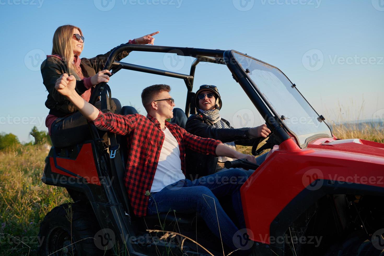 group young happy people enjoying beautiful sunny day while driving a off road buggy car photo