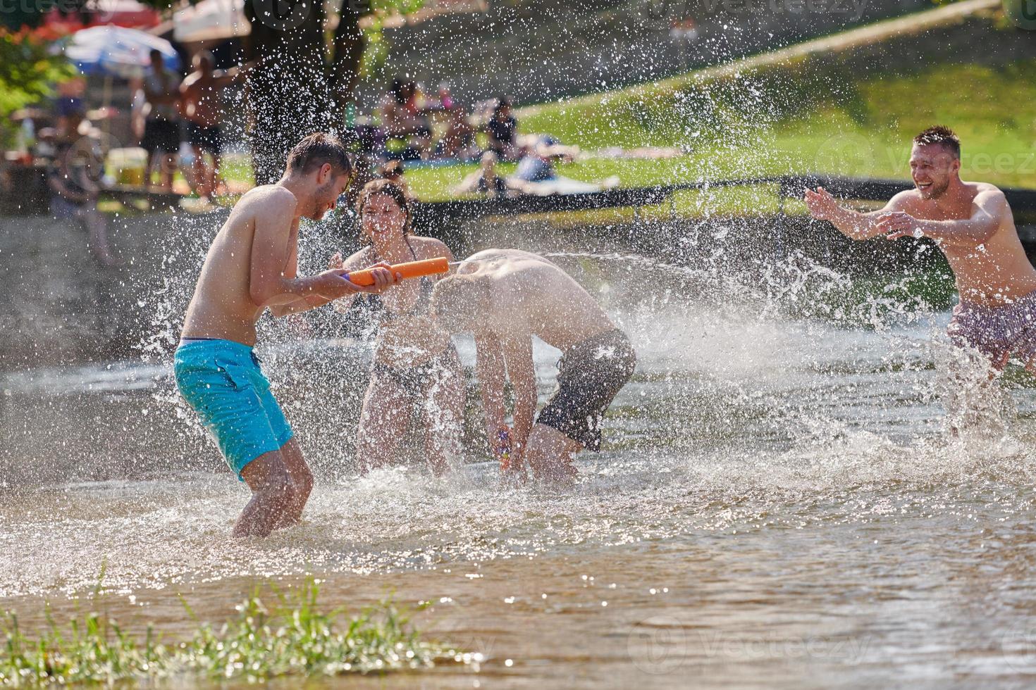 group of happy friends having fun on river photo