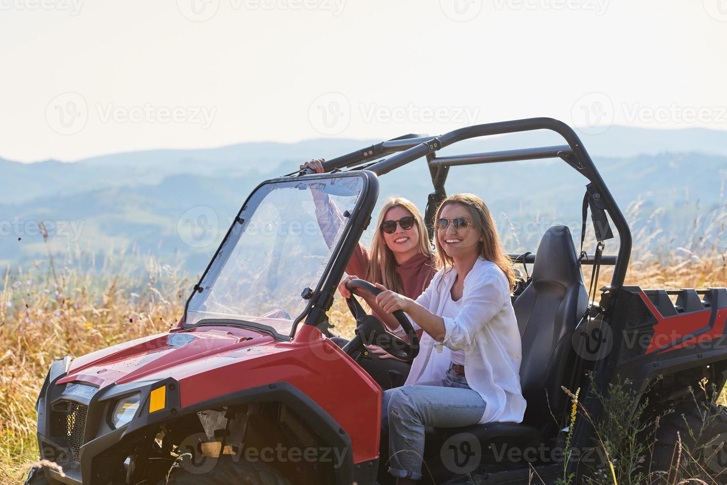 girls enjoying a beautiful sunny day while driving an off-road car photo