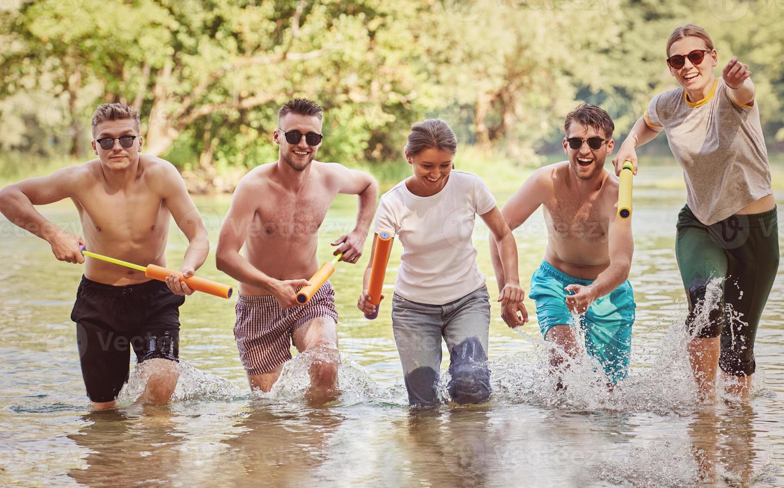 grupo de amigos felices divirtiéndose en el río foto