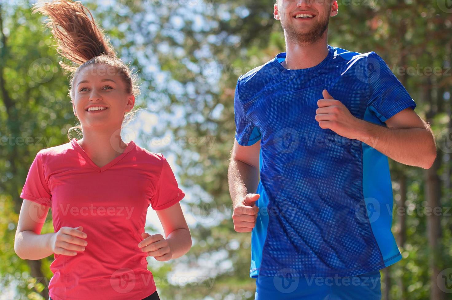 couple enjoying in a healthy lifestyle while jogging on a country road photo