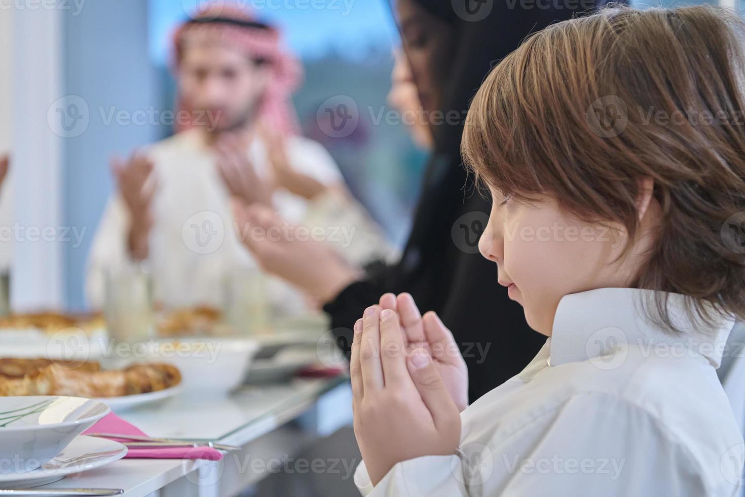 Muslim family making iftar dua to break fasting during Ramadan. photo