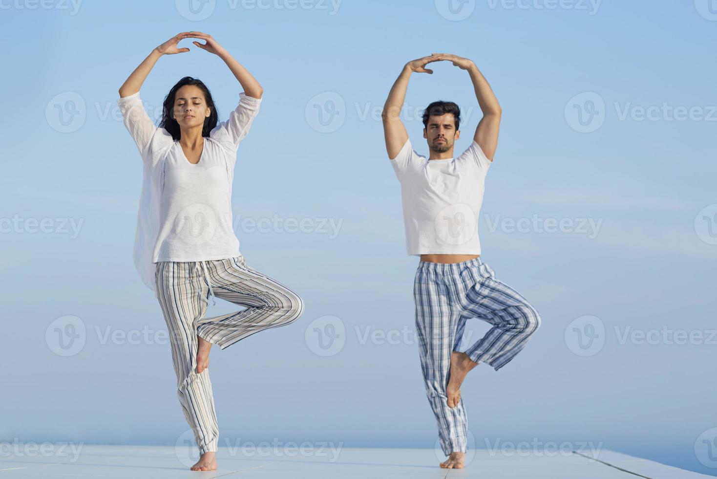 young couple practicing yoga photo