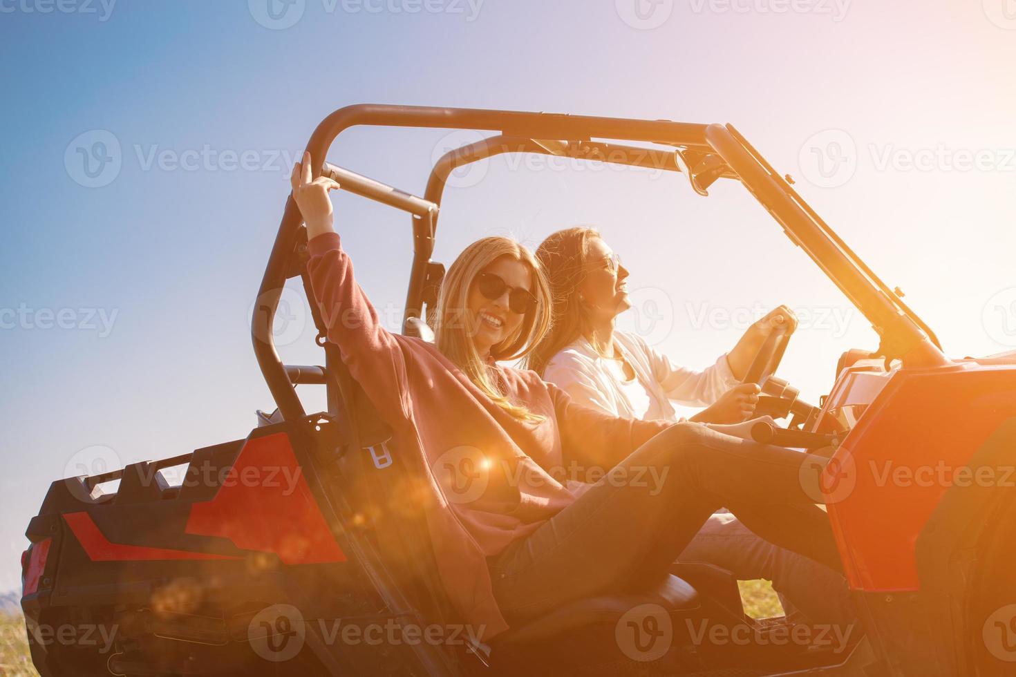two young women driving a off road buggy car photo