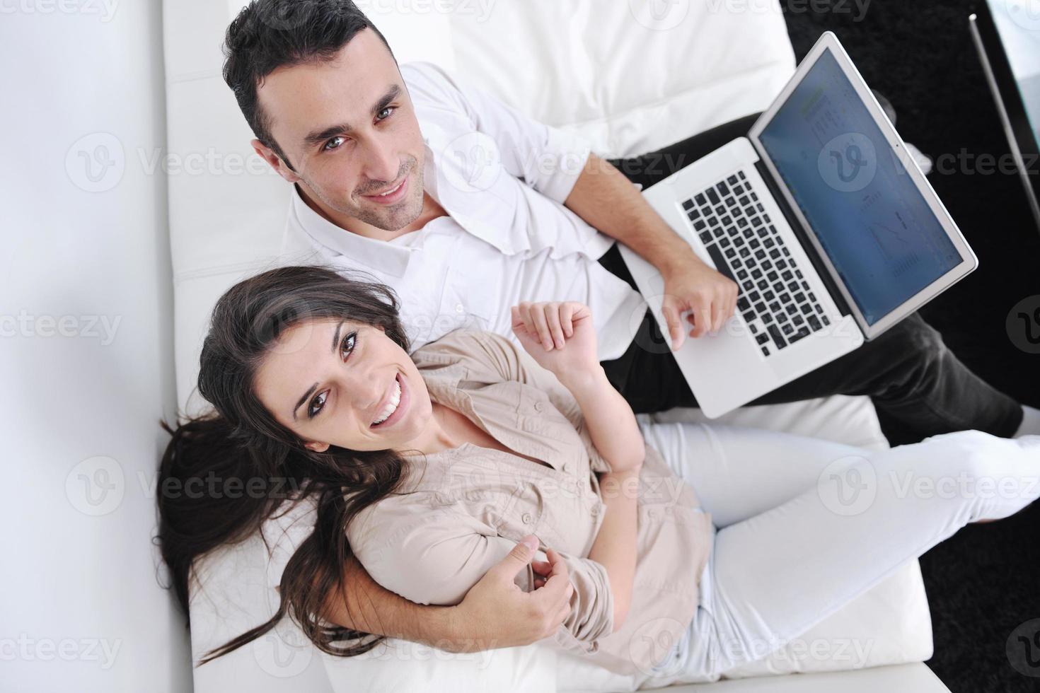 joyful couple relax and work on laptop computer at modern home photo
