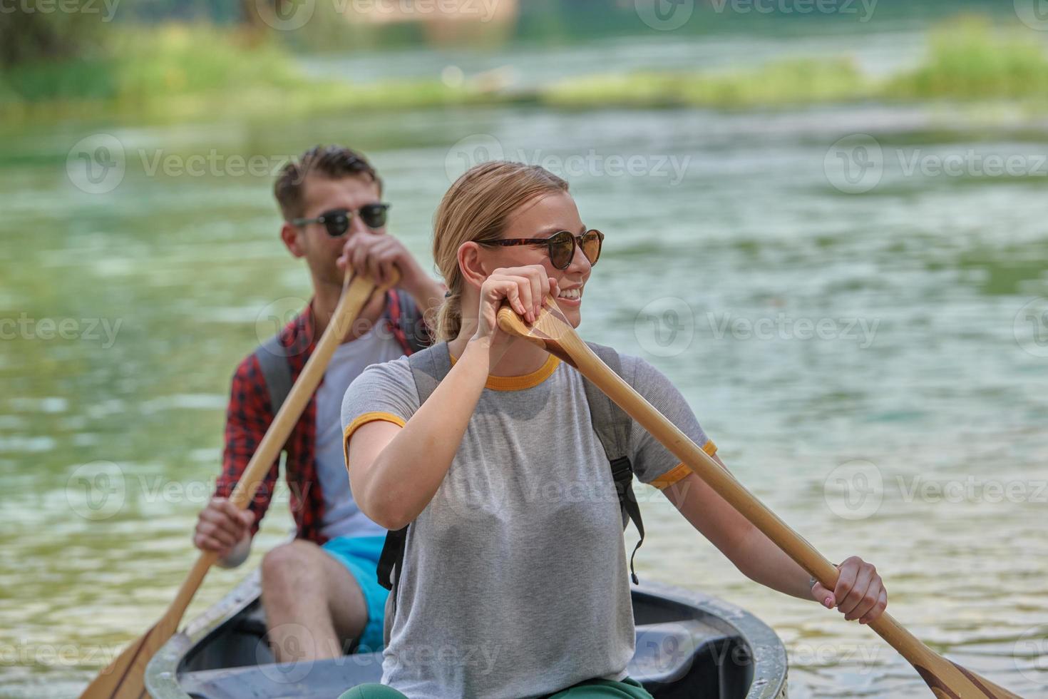 friends are canoeing in a wild river photo